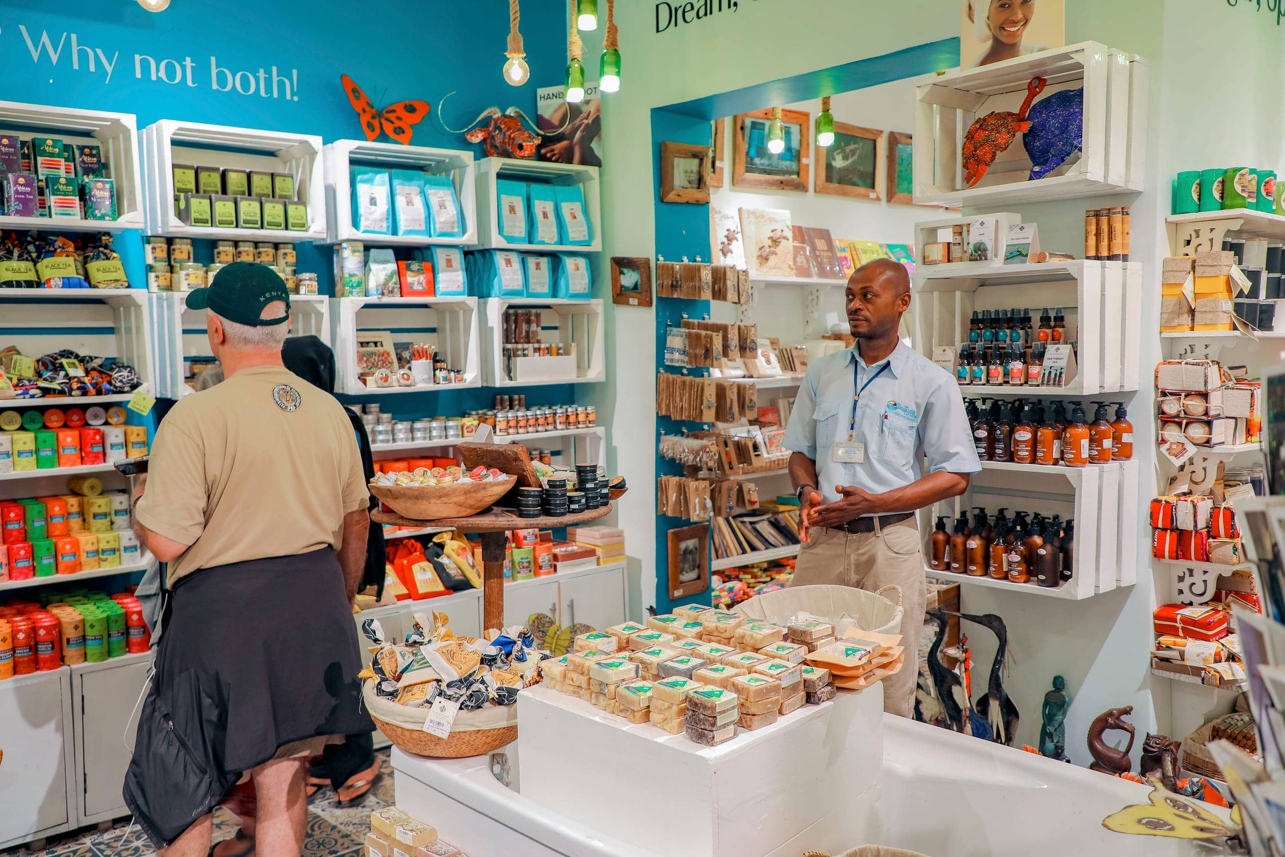A Tima Tours guide in a Stone Town spice and craft shop while a guest browses the shelves